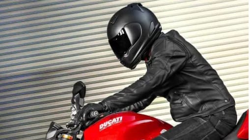 Motorcyclist wearing a black helmet on a red motorcycle