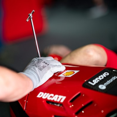 Ducati Corse team leaning on Ducati Motorbike.